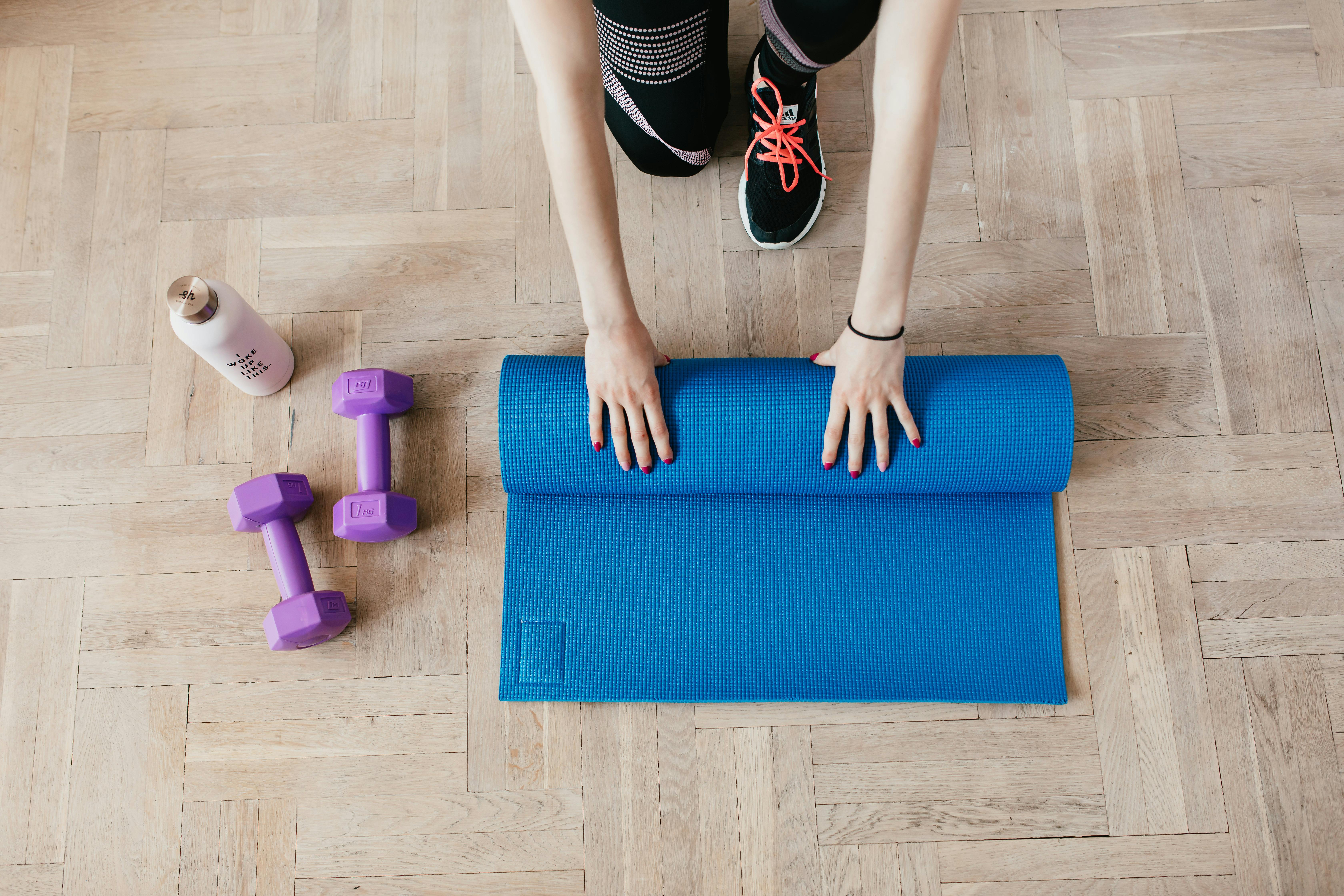 Mat being unrolled and light dumbbells